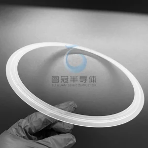 White gloved hand holding a semi-transparent Fused Quartz ring with a double-grooved profile