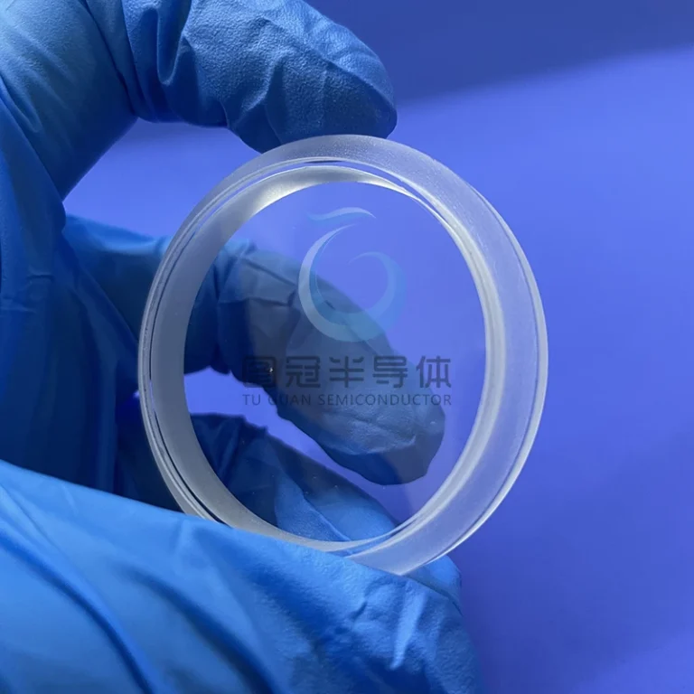 a clear, round Fused Quartz optical window or disk with a frosted edge.
