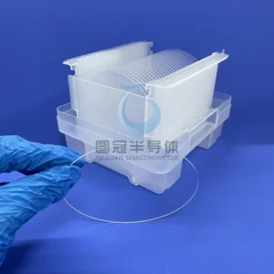 a clear, thin 4-inch Fused Quartz wafer with a transparent plastic wafer cassette in the background.