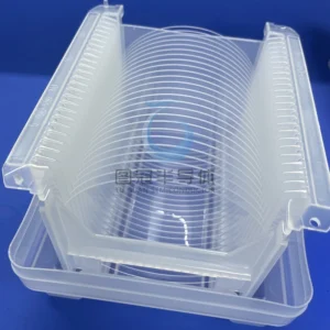 Multiple clear Fused Quartz wafers stacked neatly inside a translucent plastic wafer cassette