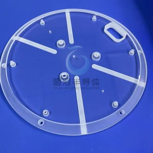 Close-up of a large, clear, circular 12-inch Fused Quartz plate with intricate etched radial lines and internal circles, resting on a blue surface