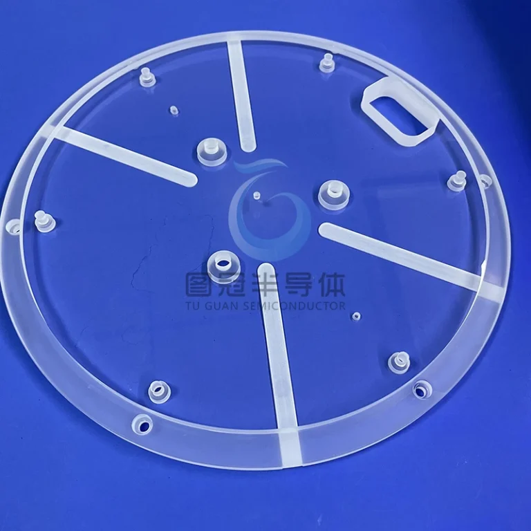 Close-up of a large, clear, circular 12-inch Fused Quartz plate with intricate etched radial lines and internal circles, resting on a blue surface