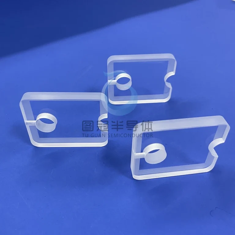 Three clear, rectangular sapphire glass plates with a central through-hole and unique cut-outs on two sides.